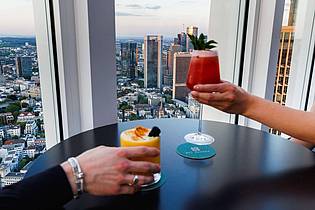 Lando Hass/dpa | Drinks mit View: Cocktails werden in der «NFT-Skybar» vor der Kulisse der Frankfurter Skyline serviert. 