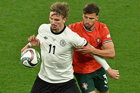 Peter Kneffel/dpa | Nick Woltemade (l) hatte bei seinem Länderspiel-Debüt gegen Portugals Abwehrrecken einen schweren Stand.