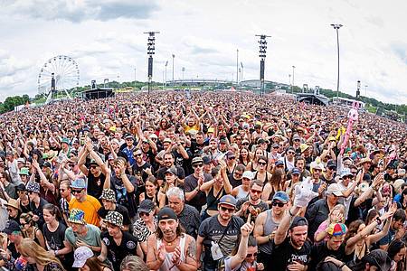 Daniel Karmann/dpa | Vorne Musik, hinten Riesenrad: Bei Festivals erwarten die Fans mittlerweile mehr als Band-Auftritte. (Archivbild)