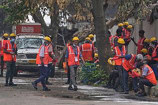 Rafiq Maqbool/AP/dpa | Arbeiter sind an der Absturzstelle im Einsatz.