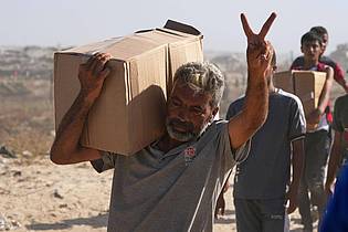 Abdel Kareem Hana/AP/dpa | An die Hilfspakete zu gelangen ist beschwerlich - der Weg nach Hause auch. 