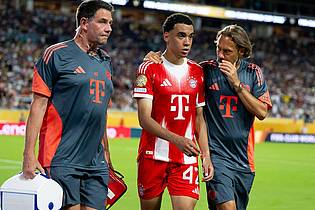 Sven Hoppe/dpa | Jamal Musiala musste nur 25 Minuten nach seiner Einwechselung angeschlagen vom Platz, begleitet von Teamarzt (r) und Physiotherapeut. 