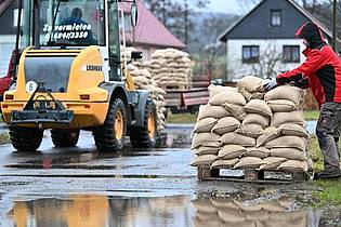 Freiwilligen Helfer verteilen Schleusinger Ortsteil Rappelsdorf in Thüringen Sandsäcke. Foto: Martin Schutt/dpa-Zentralbild/dpa