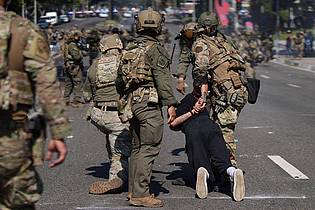 Eric Thayer/AP/dpa | Die militärisch anmutenden Sicherheitskräfte des Bundes nehmen Demonstranten fest.