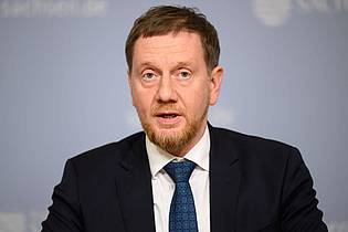 Robert Michael/dpa | Die Länder seien sich einig in ihrer Forderung nach Ersatz ihrer Kosten, sagt der Vorsitzende der Ministerpräsidentenkonferenz, Michael Kretschmer. (Archivbild)