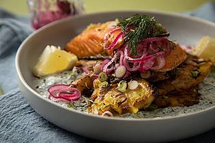 Christin Klose/dpa-tmn | Eingelegte rote Zwiebeln toppen den Schweden-Salat mit crispy smashed Potatoes und Lachs.