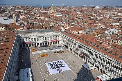 Greenpeace/Greenpeace/AP/dpa | Greenpeace protestiert mit einem großen Transparent auf dem Markusplatz in Venedig gegen die Bezos-Hochzeit.