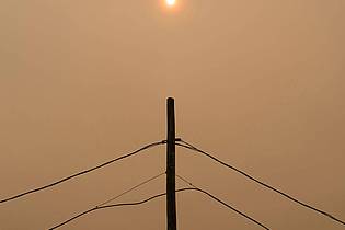 David Lipnowski/The Canadian Press/AP/dpa | Rauch verdeckt die Sonne, während Waldbrände im Norden Manitobas wüten.