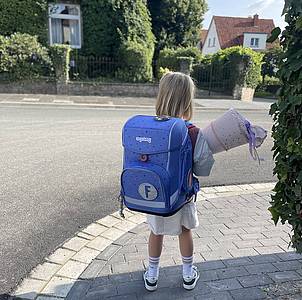 Kind mit Schulranzen auf dem Rücken 