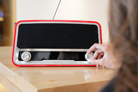 Frau schaltet Radio ein