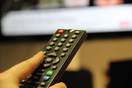 Jemand schlatet mit einer TV-Fernbedienung