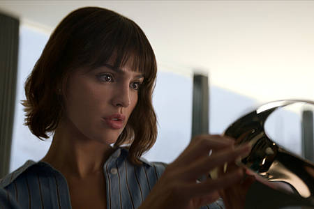 Eiza González als Auggie Salazar begutachtet eine Virtual Reality Brille